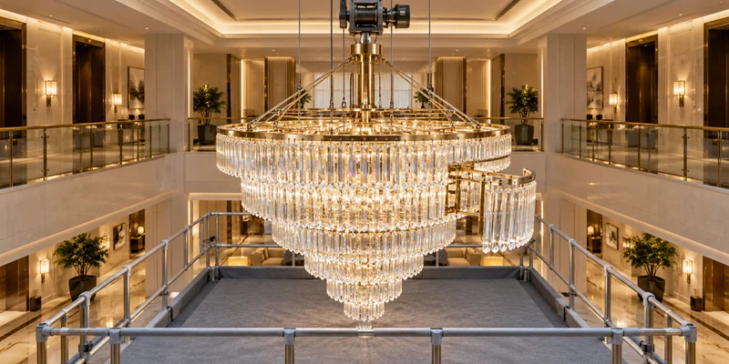 Large hotel chandelier lowered to a protected service platform for sectional maintenance Large hotel chandelier lowered to a protected service platform for sectional maintenance