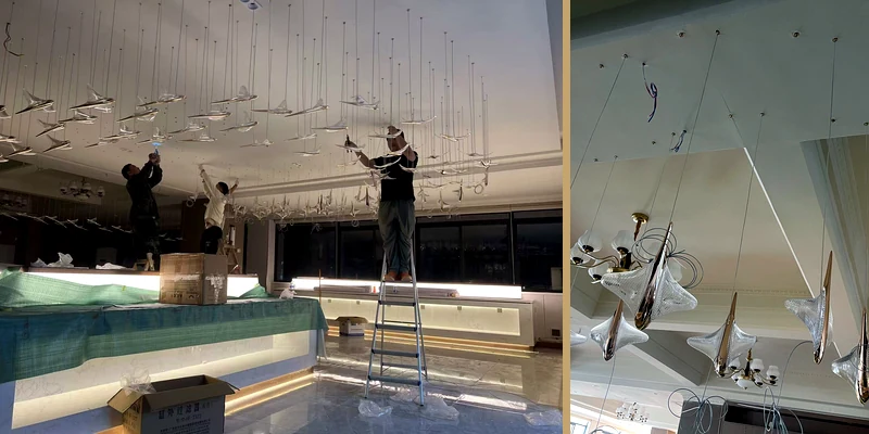 Installers arranging components and suspension lines for a long drop staircase chandelier Installers arranging components and suspension lines for a long drop staircase chandelier