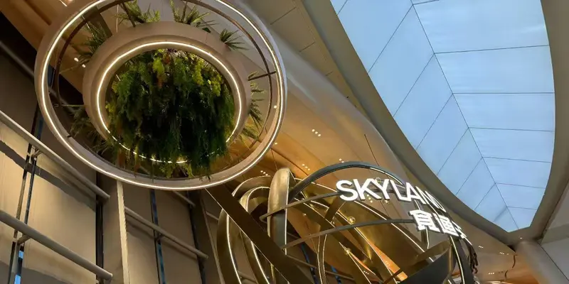 Organic chandelier design with illuminated circular forms and bronze curves in an open atrium
