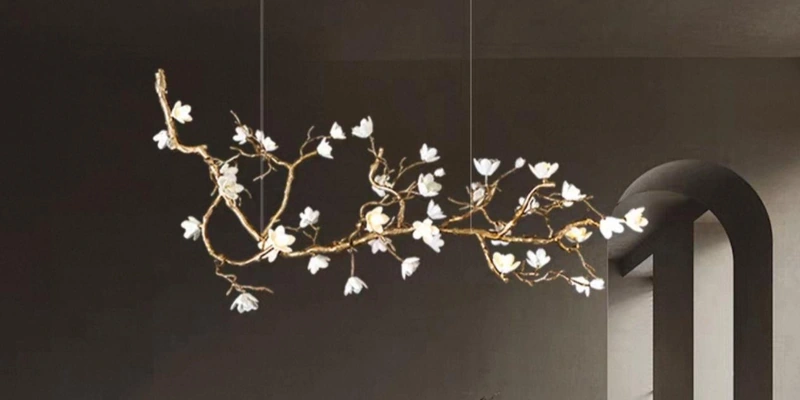 White floral chandelier on a gold-tone branch frame against an arched interior White floral chandelier on a gold-tone branch frame against an arched interior