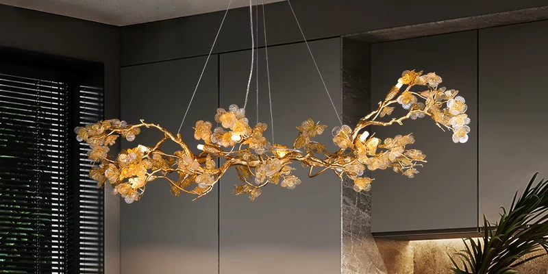 Gold-tone branch chandelier with translucent decorative elements against a dark wall Gold-tone branch chandelier with translucent decorative elements against a dark wall