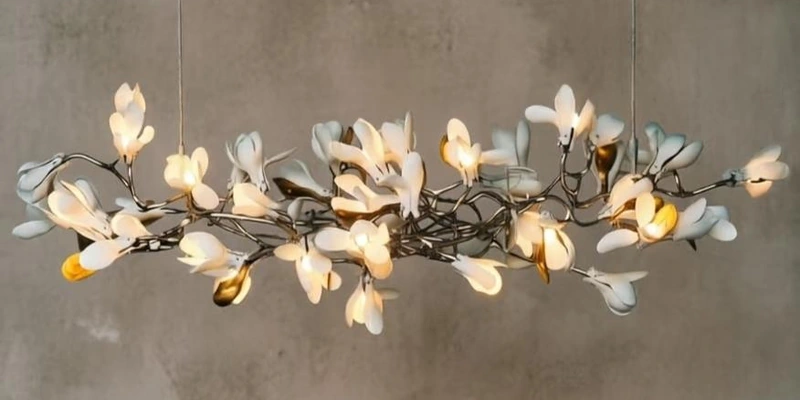 Illuminated white flower chandelier with gold accents and branching metal stems Illuminated white flower chandelier with gold accents and branching metal stems