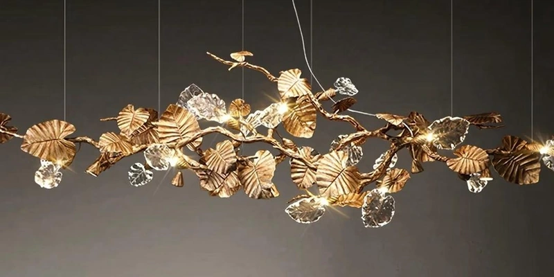 Gold-tone branch chandelier with clear leaf-shaped elements and textured metal leaves Gold-tone branch chandelier with clear leaf-shaped elements and textured metal leaves