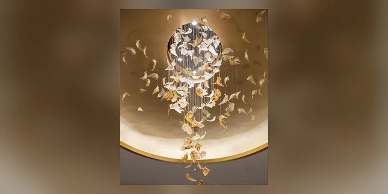 Finished sculptural chandelier compared with its original design rendering